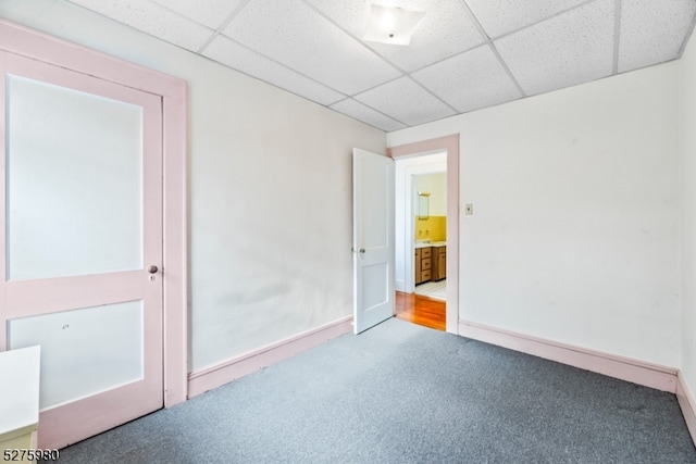 carpeted spare room featuring a drop ceiling