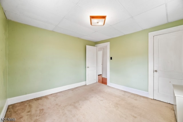 carpeted spare room with a drop ceiling