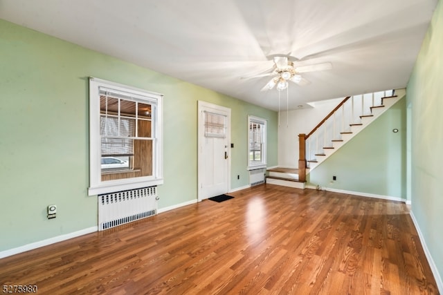 foyer entrance featuring ceiling fan, radiator, and hardwood / wood-style flooring