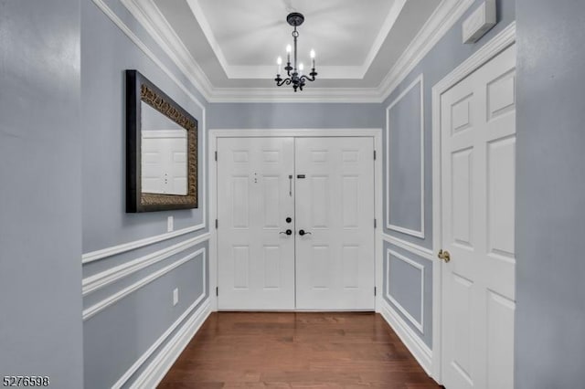 1103 Enclave Cir, Franklin Twp, NJ 08873 - foyer entrance featuring a chandelier, dark wood-style floors, ornamental molding, a raised ceiling, and a decorative wall