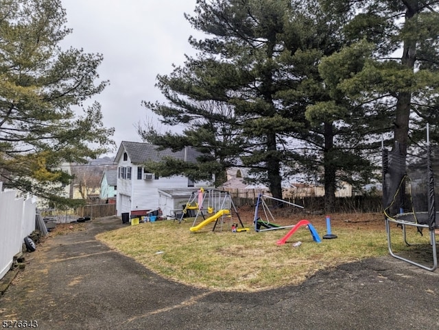 view of yard featuring a playground and a trampoline