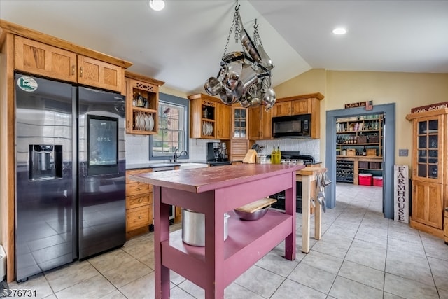 kitchen featuring a chandelier, tasteful backsplash, light tile floors, black appliances, and lofted ceiling