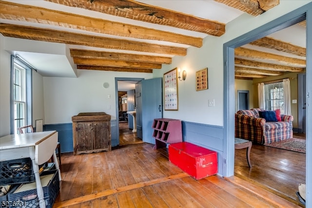 interior space with dark wood-type flooring and beam ceiling