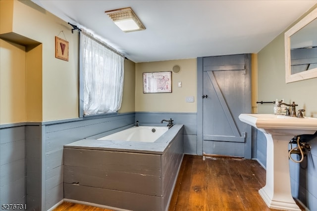 bathroom featuring a washtub and wood-type flooring