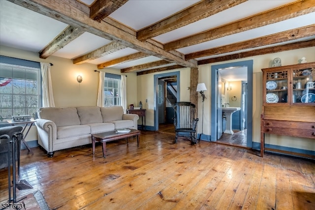 living room featuring beamed ceiling and dark hardwood / wood-style floors