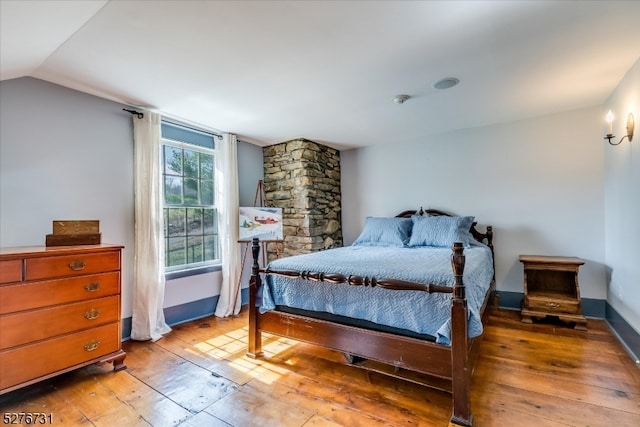 bedroom with lofted ceiling and hardwood / wood-style floors