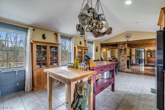 tiled dining area featuring vaulted ceiling