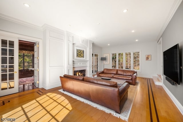 living room featuring light hardwood / wood-style flooring, french doors, and crown molding