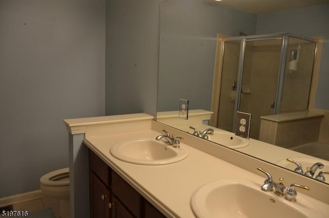 full bathroom featuring a sink, toilet, and a shower stall