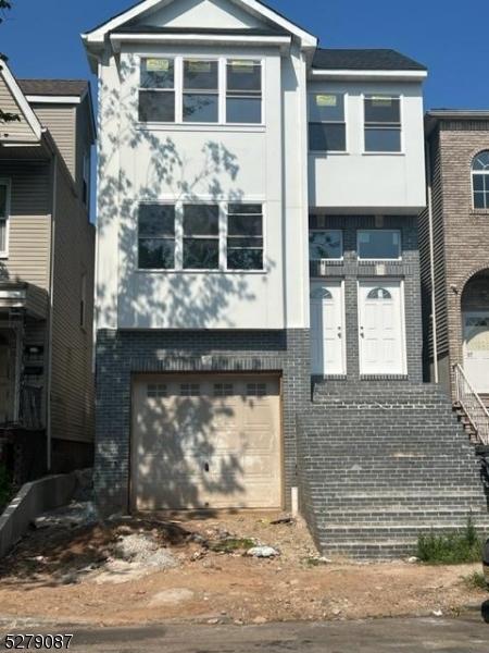 view of front facade featuring brick siding and a garage