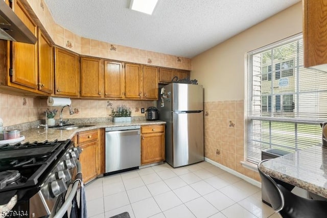 193 Columbus Dr Unit 193, Franklin Twp, NJ 08823 - kitchen with stainless steel appliances, a sink, wall chimney range hood, brown cabinetry, and tile walls
