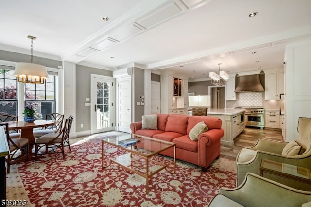 living room featuring light hardwood / wood-style floors, a chandelier, and crown molding