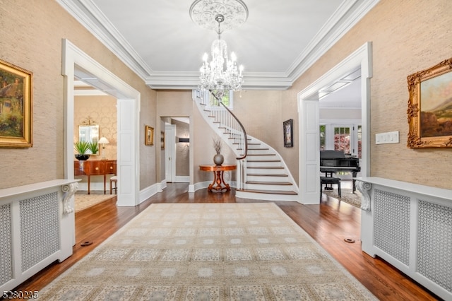 entrance foyer featuring a chandelier, crown molding, radiator, and dark hardwood / wood-style floors