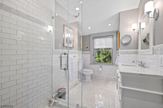 bathroom featuring tile walls, large vanity, tasteful backsplash, walk in shower, and toilet