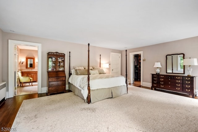 bedroom featuring a spacious closet, dark hardwood / wood-style flooring, and a closet