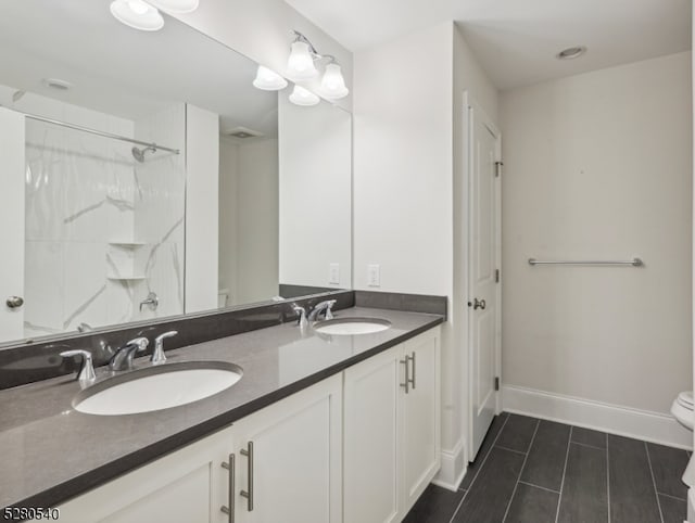 bathroom featuring dual sinks, tile floors, toilet, and large vanity