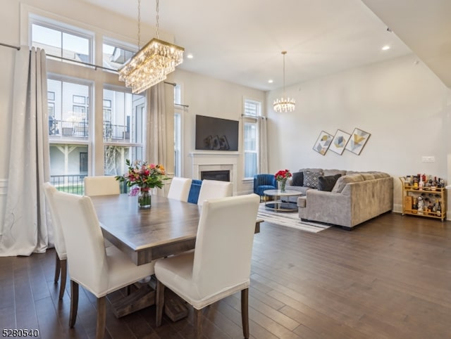 dining room with dark hardwood / wood-style floors and an inviting chandelier