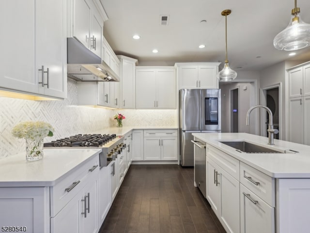 kitchen with decorative light fixtures, sink, white cabinetry, and stainless steel appliances