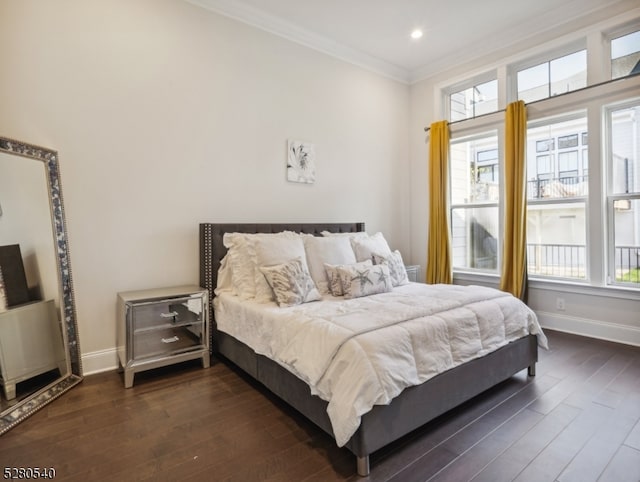 bedroom with ornamental molding and dark hardwood / wood-style flooring