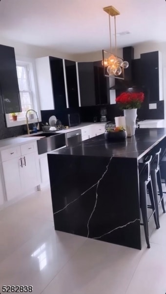 kitchen with a chandelier, decorative light fixtures, light tile floors, and white cabinetry