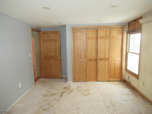 unfurnished bedroom featuring a closet and baseboards