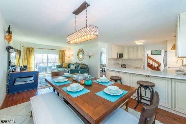 dining space featuring wood-type flooring and sink