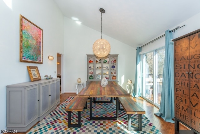 dining space featuring light hardwood / wood-style floors, lofted ceiling, and a chandelier