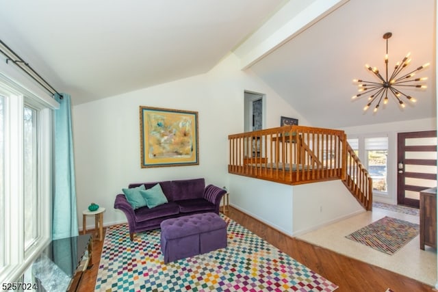 living room featuring a notable chandelier, lofted ceiling, a healthy amount of sunlight, and wood-type flooring