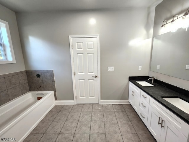 bathroom with tile patterned floors, a tub to relax in, and vanity