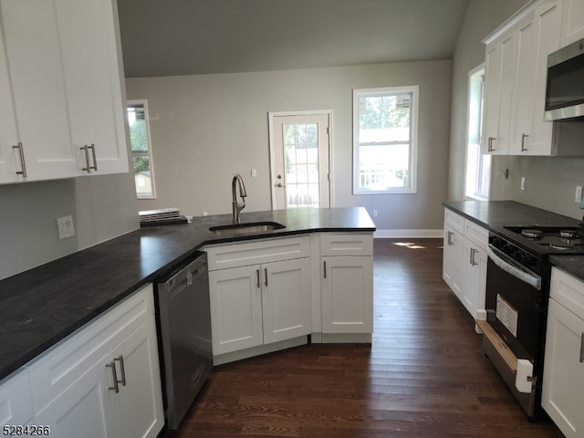 kitchen with lofted ceiling, white cabinets, dark wood-type flooring, sink, and appliances with stainless steel finishes