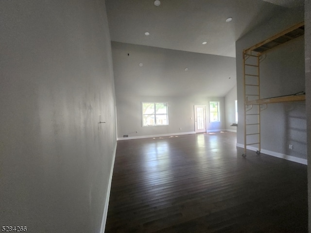 empty room with dark wood-type flooring and lofted ceiling