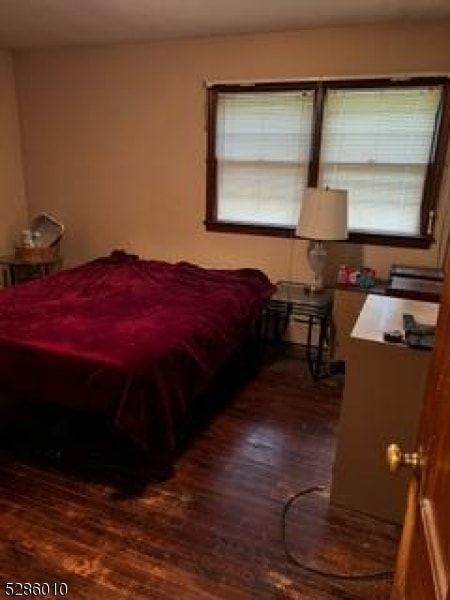 bedroom with dark hardwood / wood-style floors