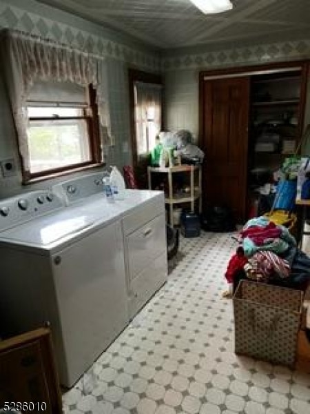 laundry room with washer and clothes dryer and light tile floors