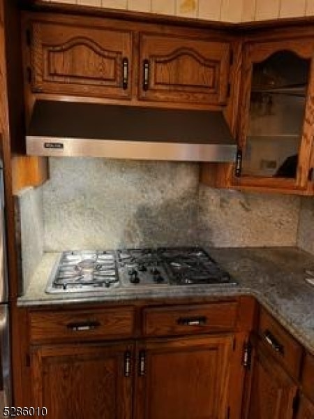 kitchen with backsplash, stainless steel gas cooktop, and wall chimney exhaust hood