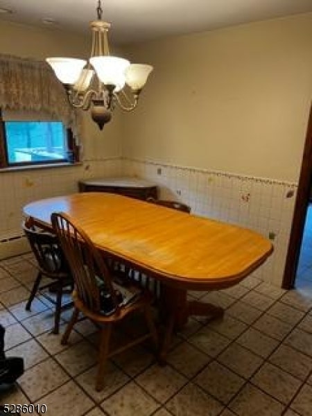 unfurnished dining area featuring a notable chandelier and tile floors