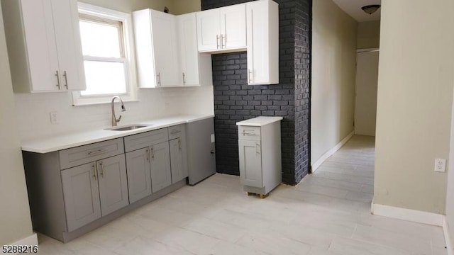 kitchen with white cabinets, gray cabinets, and sink