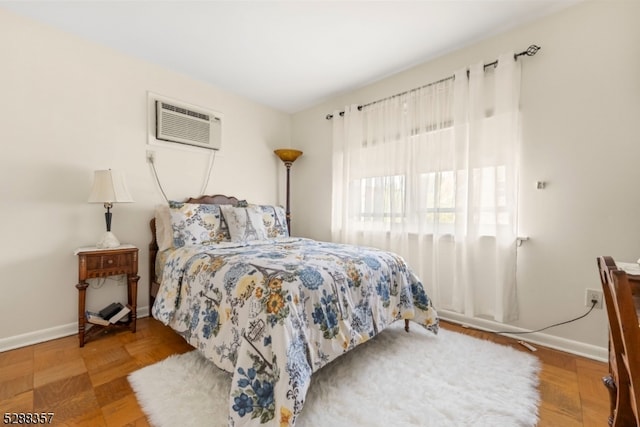 bedroom featuring a wall unit AC and parquet flooring