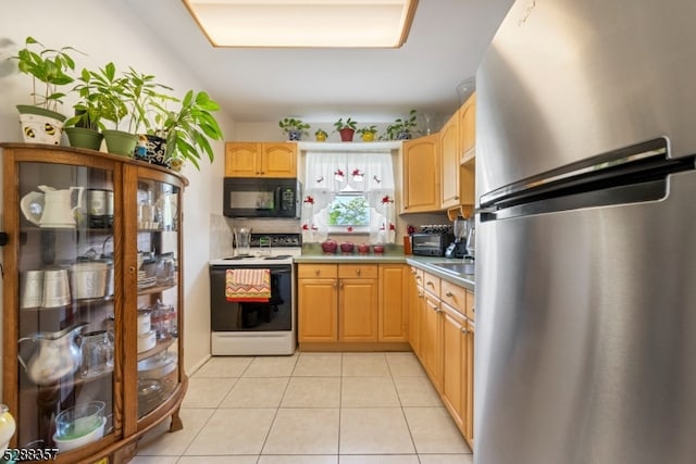 kitchen featuring light brown cabinets, stainless steel refrigerator, electric range, and light tile floors