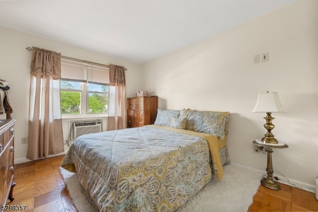 bedroom with an AC wall unit and parquet floors