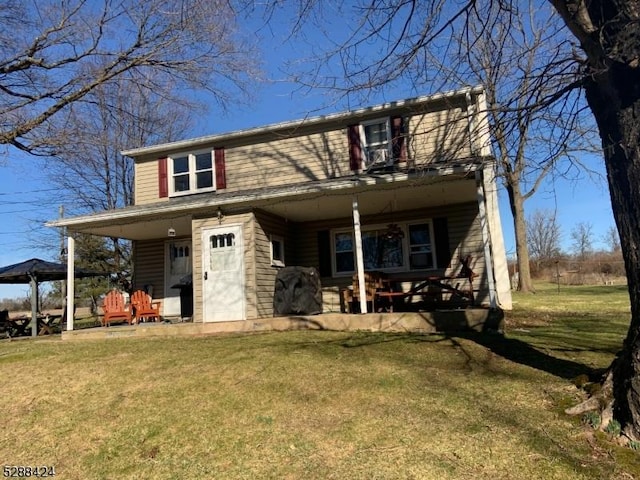 view of front of house with a front yard, a gazebo, and covered porch