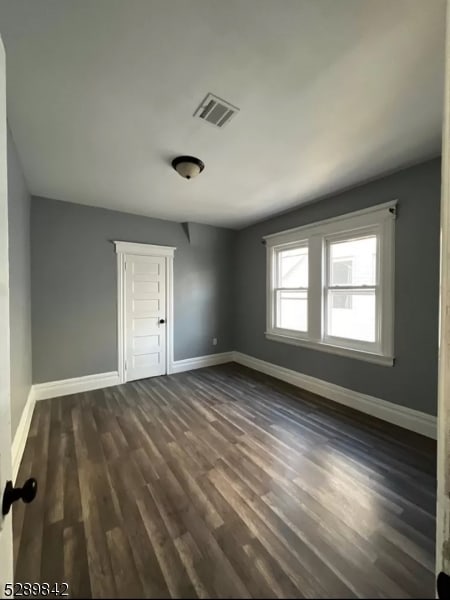 unfurnished room featuring dark wood-type flooring