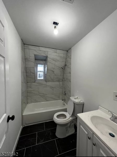 full bathroom with tile floors, toilet, vanity, and tiled shower / bath