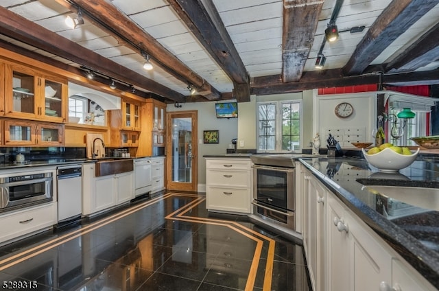 kitchen with beamed ceiling, white cabinetry, and dishwasher