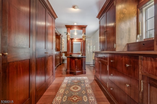 hall with sink and light wood-type flooring