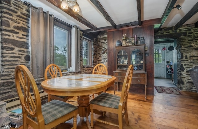 dining room featuring hardwood / wood-style floors and beamed ceiling