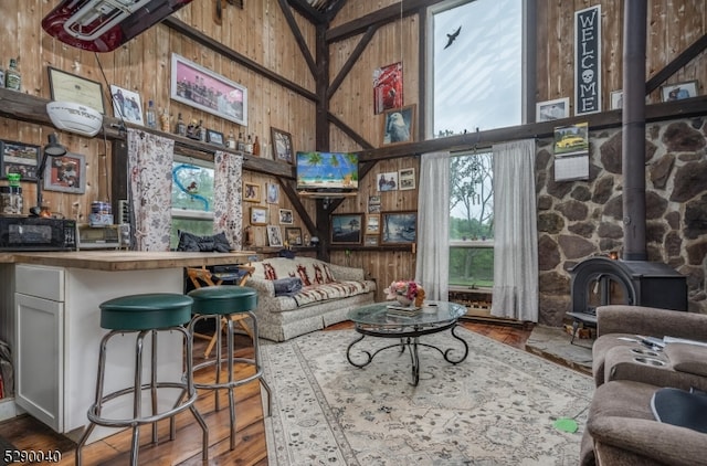 interior space with hardwood / wood-style floors, a wood stove, and wood walls