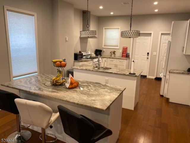 kitchen featuring a center island with sink, wall chimney exhaust hood, recessed lighting, white cabinets, and dark wood-style flooring