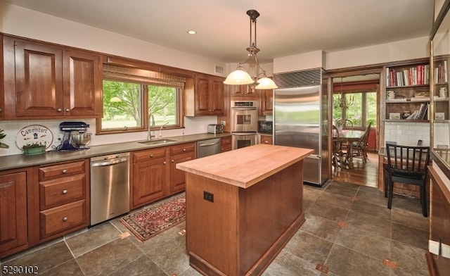 kitchen with backsplash, appliances with stainless steel finishes, and dark tile floors