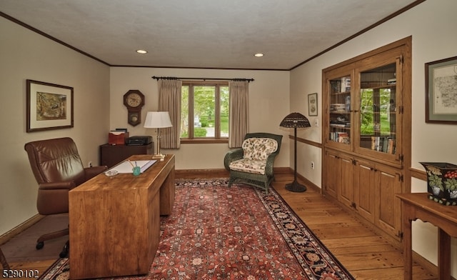 office with ornamental molding and hardwood / wood-style flooring