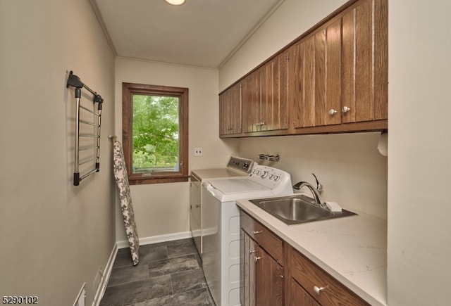 washroom with cabinets, dark tile floors, washing machine and clothes dryer, washer hookup, and sink